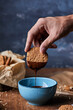 © Foodlovers - Dipping walnut cookie in melted chocolate