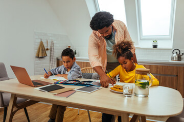 Wall Mural - Afro students doing homework at home with school books helped by their father. Dad control, help and teaching their children