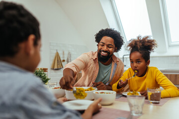 Afro family eating lunch together around the kitchen table