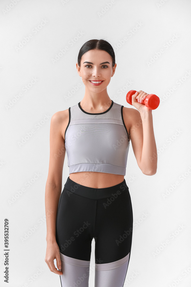 Sportive female coach on light background