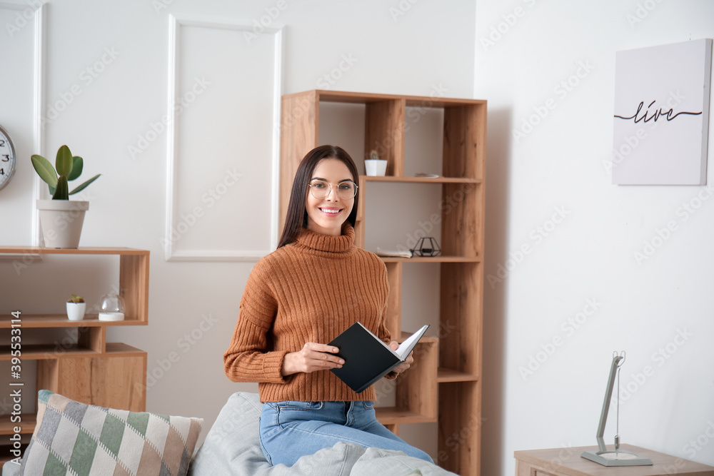 Young woman reading book at home