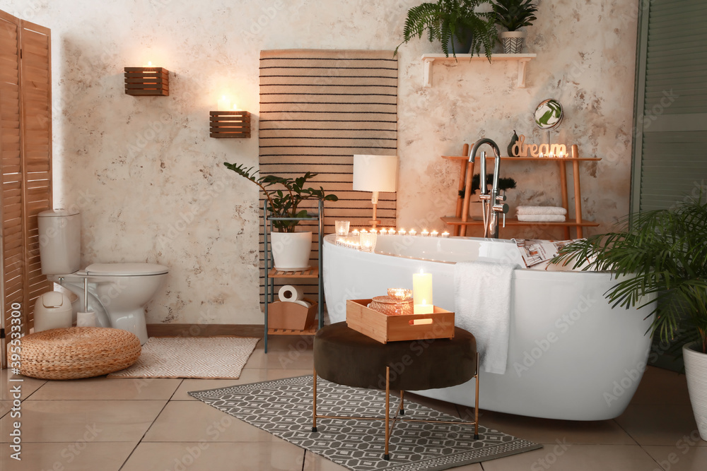 Interior of modern bathroom with burning candles in evening - obrazy, fototapety, plakaty 