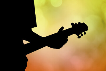 Silhouette of guitar player in concert with purple light