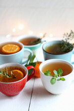 Cups Of Tea With Various Herbs And Orange Slices