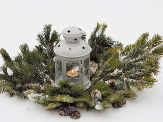 Wall Mural - Romantic New Year is lantern with a candle standing on fir branches in the snow in the forest. Wonderful winter evening. Congratulatory background.