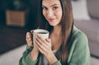 © deagreez - Cropped photo of optimistic girl drink coffee from home wear green shirt indoors