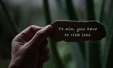 Hands Holding Torn paper with motivational quote and blurred dark background