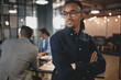 © Flamingo Images - Confident young businessman standing with his arms crossed at wo