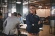 © Flamingo Images - Young businessman smiling while working in a modern office