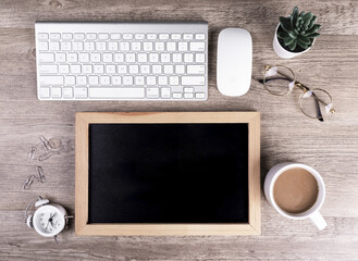 Wall Mural - Top view of an office desk with a blank chalkboard