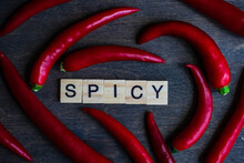 Cooking Concept With Red Hot Chili Peppers In Heart Shape With Wooden Blocks SPICY On Wooden Table With Copy Space