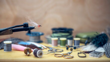 Fishing Fly Tying Materials And Tools On A Wooden Table