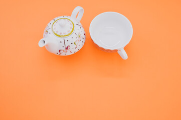 Wall Mural - Top view of a decorative teapot with cup isolated on an orange background