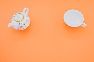 Sticker - Top view of a teapot with a cup isolated on an orange background