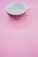 Wall Mural - Vertical shot of decorative cup isolated on pink background