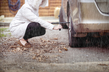 Sticker - Closeup shot of a girl repairing a car wheel