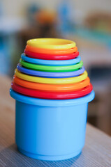 Wall Mural - Vertical selective focus shot of plastic toy cups pyramid