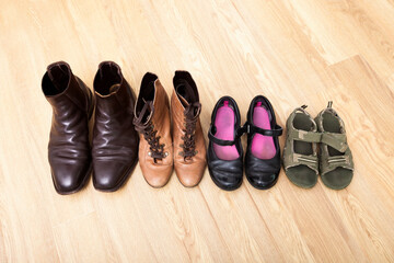Family shoes placed in a row on hardwood floor