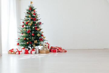 big beautiful christmas tree decorated with beautiful shiny baubles and many different presents on w