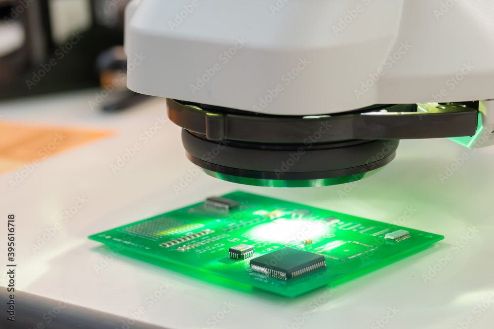 Printed circuit board under industrial microscope at plant, factory ...