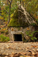 Closeup Of A Cone-shaped Military Pillbox Covered With Moss, An Old Construction In The Wood