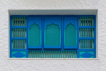 Tunisian Turquoise Slatted Wooden Shutters On Windows At Plastered Wall