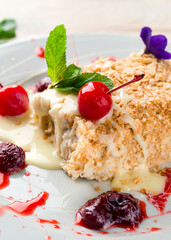 Canvas Print - Light dessert classic Napoleon or millefeuille cake decorated with mint and strawberries. On a white plate, on a white wooden table