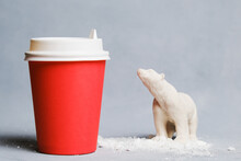 Global Warming, Environmental Issues And Pollution Concept. Disposable Cup And Toy Polar Bear. Climate Change Problem.