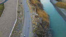 People Run Along A Riverside Trail To Support A Community Event  - Aerial View Looking Down