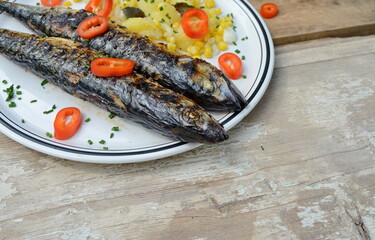 Grilled Mackerel fish on a white plate. Fatty, oily fish is an excellent and healthy source of DHA and EPA, which are two key types of omega-3 acid.