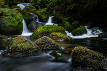 Closeup Shot Of A Waterfall Surrounded By Mossy Rocks