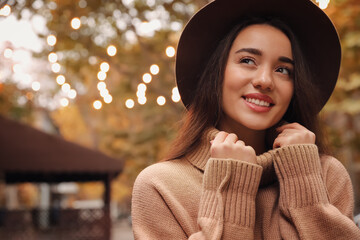 Wall Mural - Young woman wearing stylish clothes outdoors, space for text. Autumn look