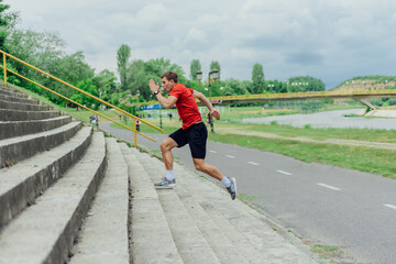 Wall Mural - Fit male athlete performing stairs workout, running up climbing stairs performing outdoor track cardio..