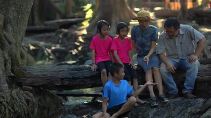 Wall Mural - Kids and mother in family playing in waterfall on mountain of travel summer holiday