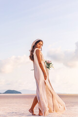 Wall Mural - beautiful young stylish woman with basket with flowers outdoors at sunset