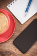 Smartphone, coffee with milk and notepad for notes. Work or relaxation with mobile phone