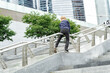mischievous boy slides down the railing on a city walk