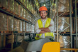 © zinkevych - Warehouse worker in orange helmet looking contented