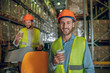 © zinkevych - Warehouse workers in orange helmets having coffee break
