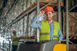© zinkevych - Warehouse worker in yellow vest touching his helmet