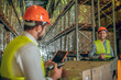 © zinkevych - Two warehouse workers in helmets talking while working