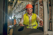 © zinkevych - Young bearded worker sitting at the loader and smiling