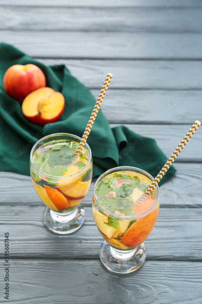 Glasses of peach mojito on wooden table