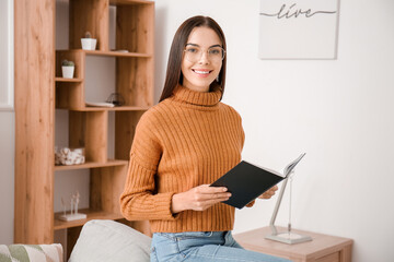 Wall Mural - Young woman reading book at home