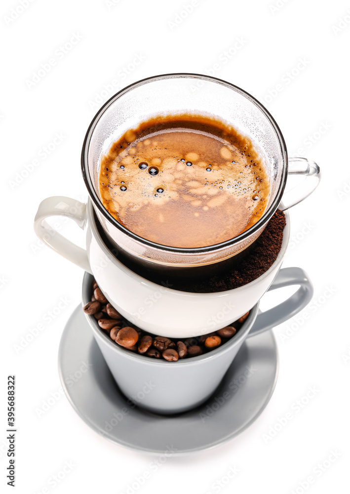 Stack of cups with coffee beans and beverage on white background