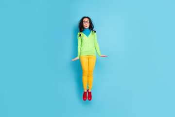 Sticker - Full length photo of funky crazy young woman jump up air wear yellow pants fly isolated on blue color background