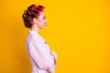 Profile side view portrait of charming cheerful woman wearing curlers folded arms copy space isolated over bright yellow color background