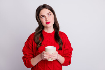 Poster - Photo portrait of thoughtful curious girl keeping mug hot beverage looking empty space isolated on pastel grey color background