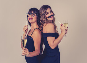 Portrait of two young attractive women with champagne glasses at celebration party