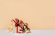 Festively wrapped gift in gold paper and ribbon with bow. Minimal Holiday Shopping backdrop